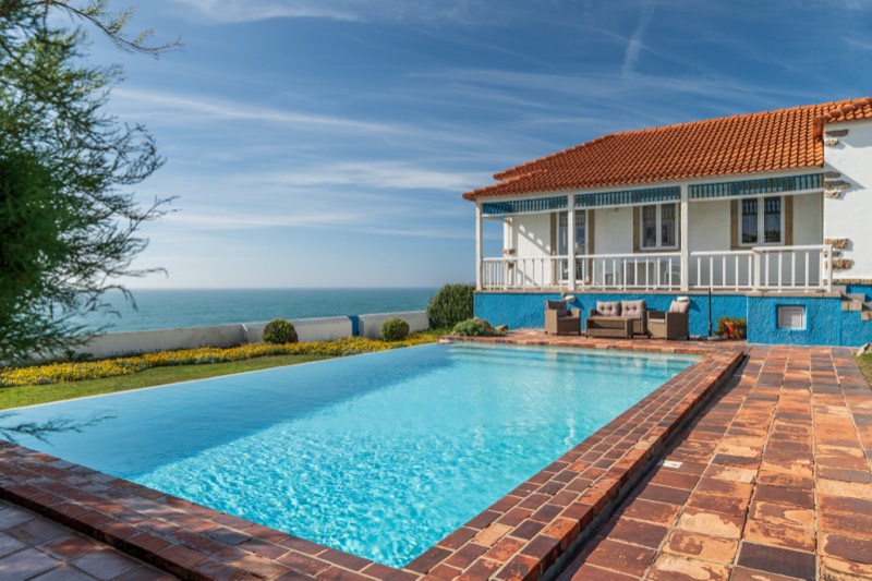 Jardim florido junto à piscina infinita e ao mar