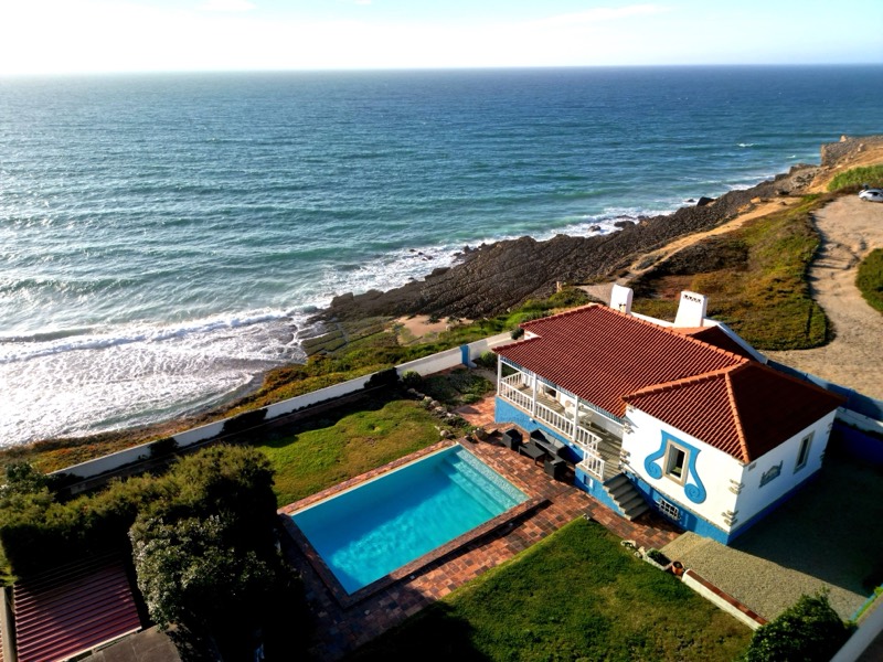 A casa, a piscina e o jardim na falésia sobre o Atlântico, vistos de cima