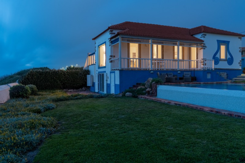 A casa e o relvado sob um céu azul profundo ao fim do dia