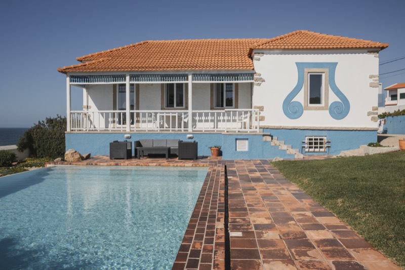 Pormenor da fachada com o ornamento azul e a piscina em baixo