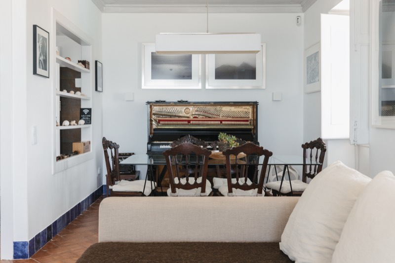 Second living room with the dining table set before the 1907 piano